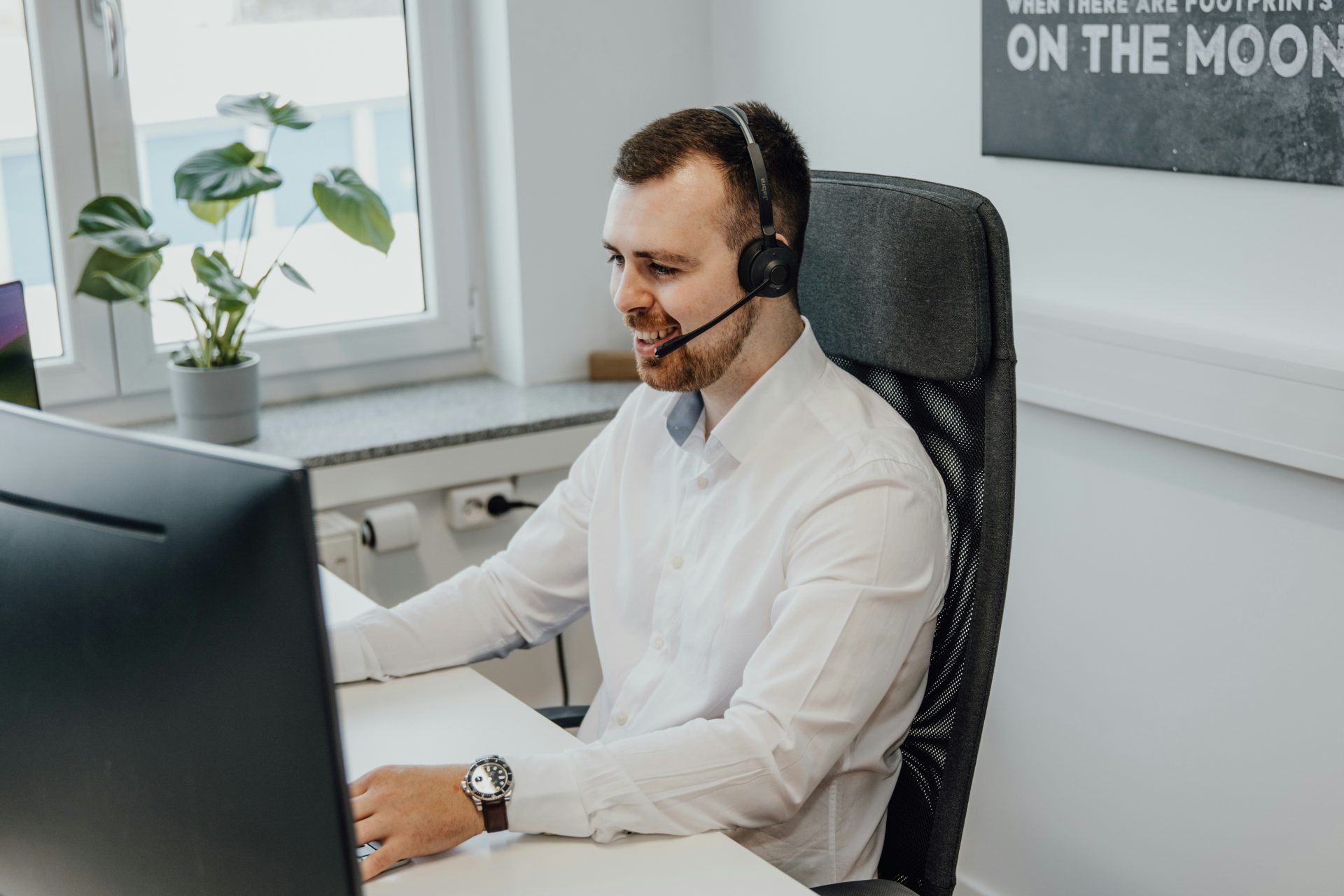 un homme portant un casque audio assis devant un ordinateur